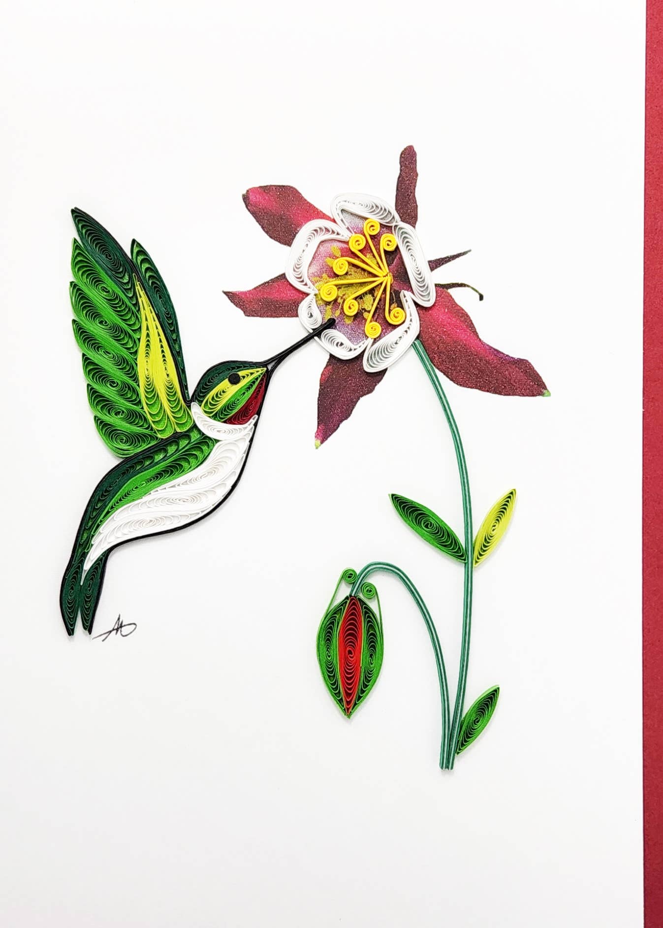 The Card: Male Hummingbird at Flower Quilling Card (5x7 inches) features quilled paper art of a green and white hummingbird feeding from a red and white flower on a white background. Comes with a red envelope.