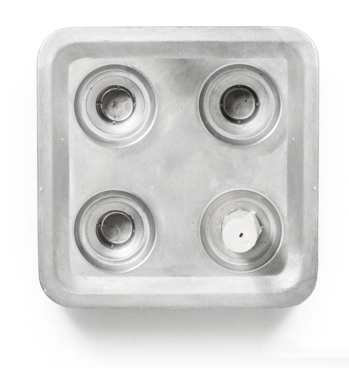 A top-down view of the Stumpastaken Fyran Four Candle Holder—square, in white powder-coated 100% recycled material—shows clean lines and practical Swedish design.