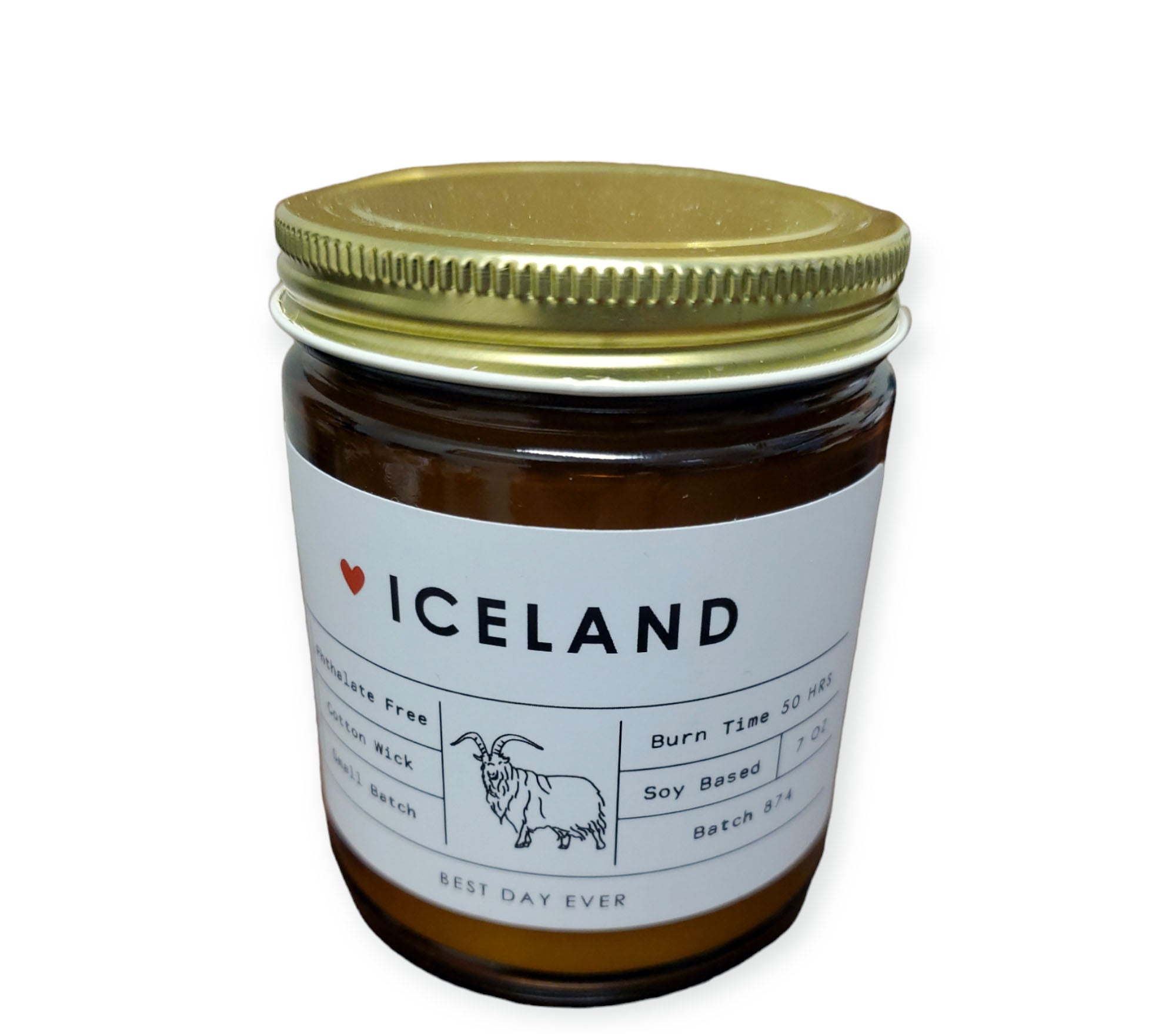 The Candle: Iceland White Label / Amber Jar / Volcano Dupe Scent features a charming goat illustration on its gold lid. Made from a soy/coconut wax blend and phthalate-free fragrances, it offers a burn time of 50 hours. Batch details are included, with "Best Day Ever" printed at the bottom.