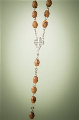 The 30 Olive Wood Rosary with Crucifix is displayed vertically on a light green background, featuring handcrafted brown wooden beads from Bethlehem and a silver connector.