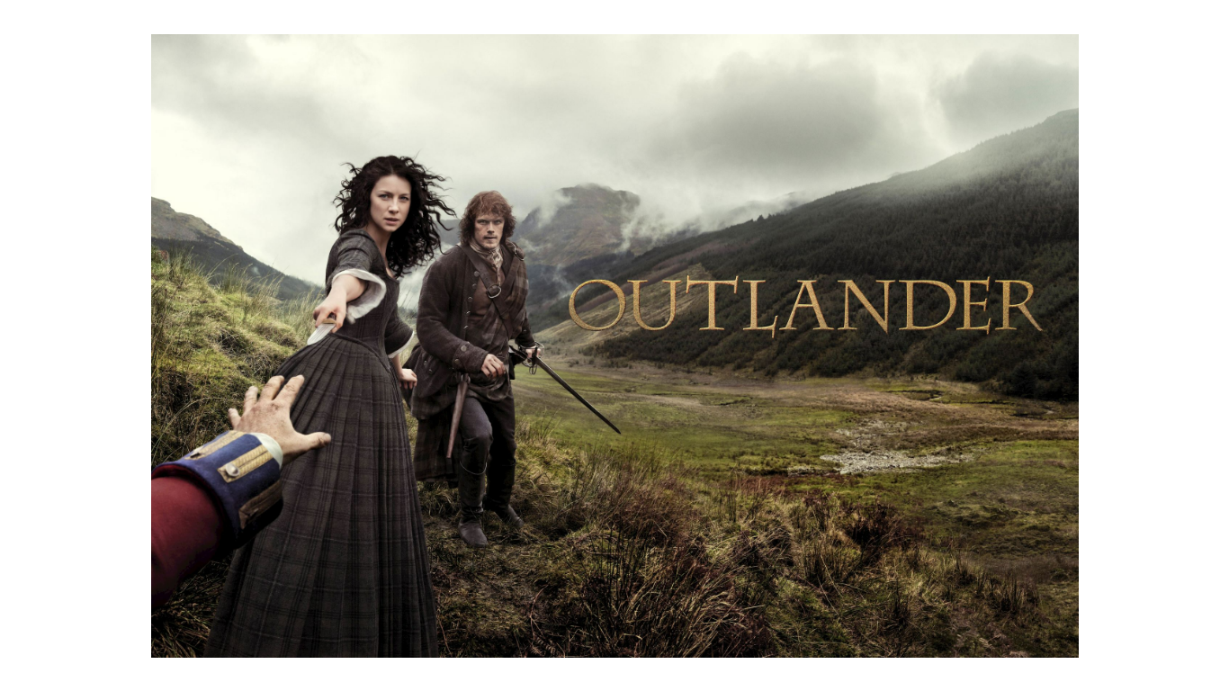 A woman reaches for a hand as a man with a sword stands behind her, both wrapped in the Blanket: Outlander Merino Wool Blanket, set against grassy mountains. OUTLANDER appears on the right.