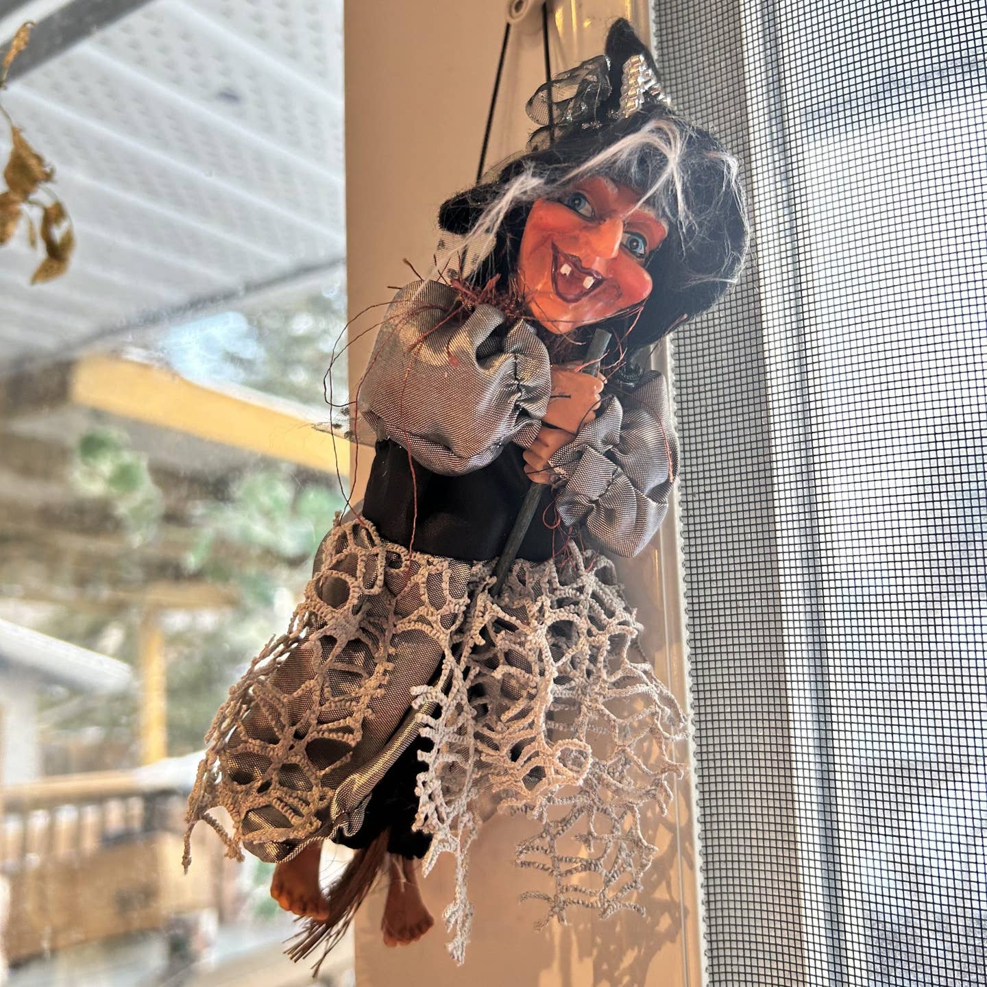 The Figurine: Kitchen Witch Doll – Sirene Silver (10.2" Tall) features a pointy hat, gray dress, and wide grin—an enchanting Northern European good luck charm perfect for displaying in your kitchen or window.