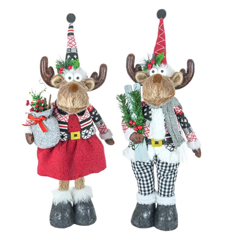 The Mr. or Mrs. Dashing Moose Stander – Festive Nordic Decor features two plush moose in holiday outfits: one with a red skirt and bag, the other with plaid pants and greenery—both topped with decorated festive hats.