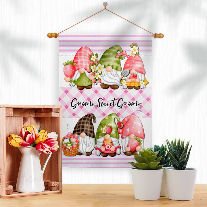 The Gnome Sweet Gnome Garden Flag showcases four gnomes with flowers and strawberries above the phrase Gnome Sweet Gnome. Made from weather-resistant fabric, this flag adds lasting charm to your outdoor decor.