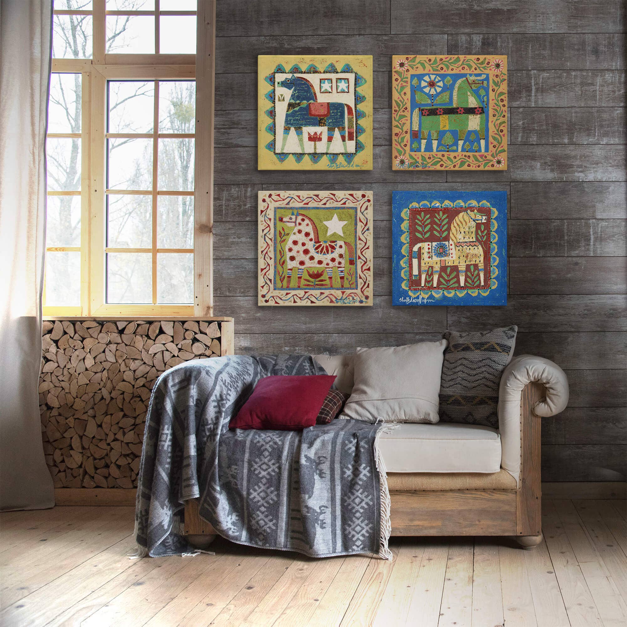 A rustic living room features a wooden wall, small couch with pillows and throw, stacked firewood, and colorful animal art including the Decor: Green Dala Horse - Metal Box Art (Aluminum Box / 18" x 18") hanging on the wall.