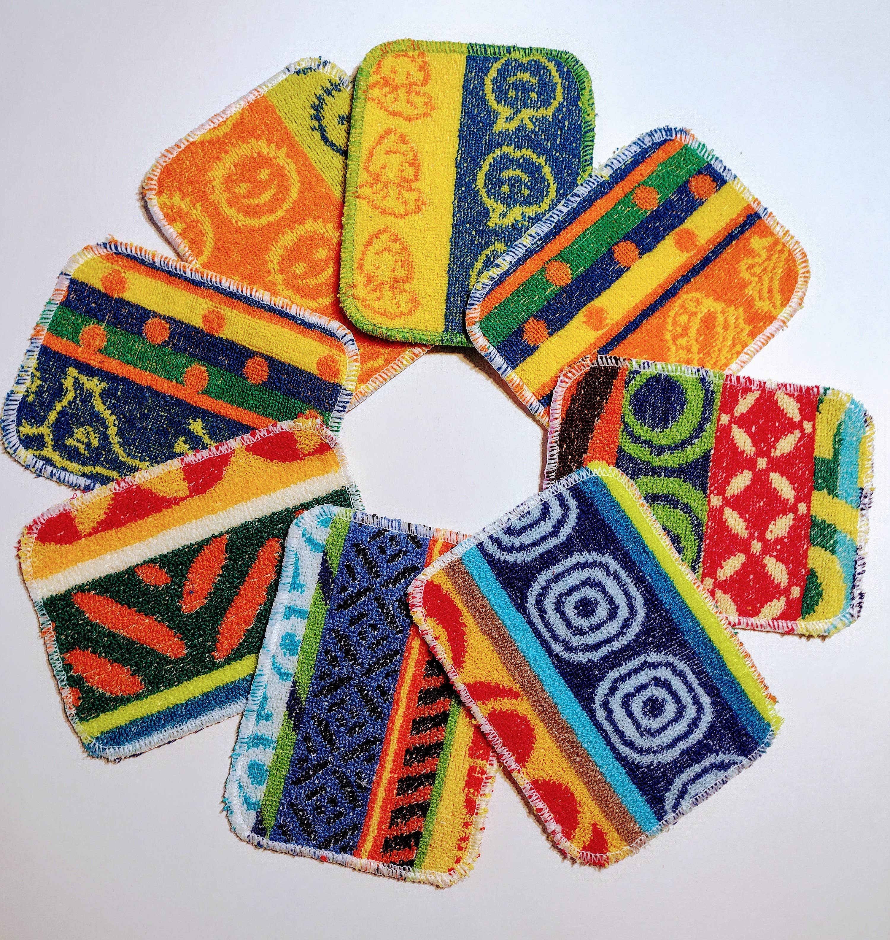 Eight vibrant, rectangular Scrub: Kitchen Scrubber Scrub-Wow pads with assorted patterns are arranged in a circle on a white background. Non-toxic and Teflon-safe, these scrubbers blend style and cleaning power.