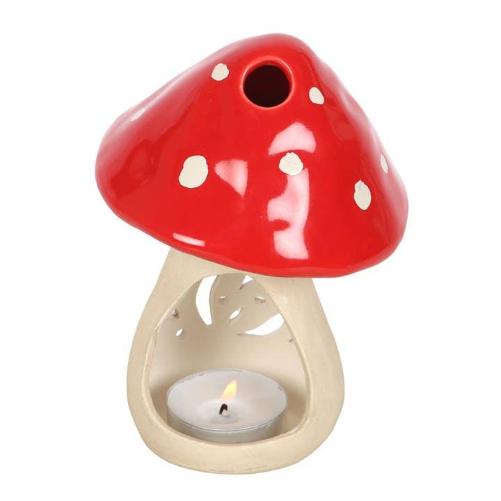 The Mushroom Tealight Candle Holder, a 6” ceramic piece with a red cap and white spots, adds charming cottagecore decor to any room, casting a playful glow when lit.