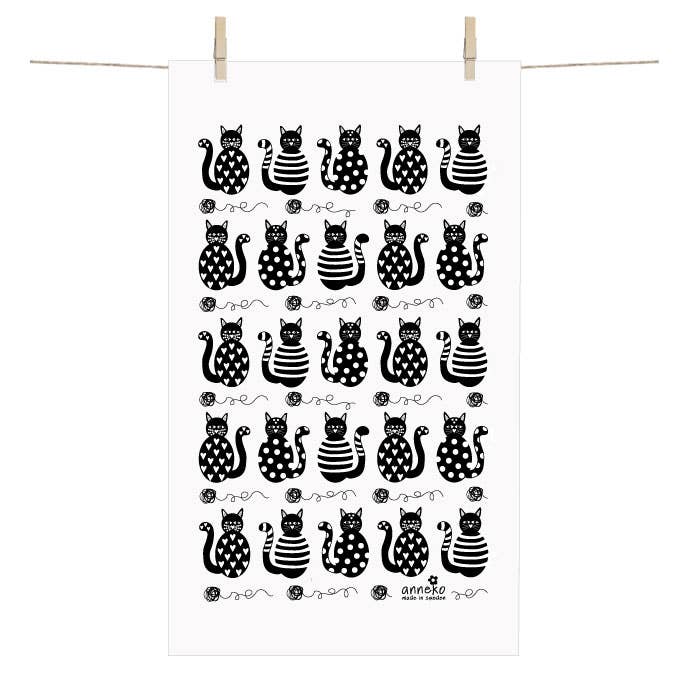 The Towel: Cat Terry-Cotton Towel by Anneko Design Sweden hangs on a line, showcasing a grid of black cats with spots, stripes, and floral accents.