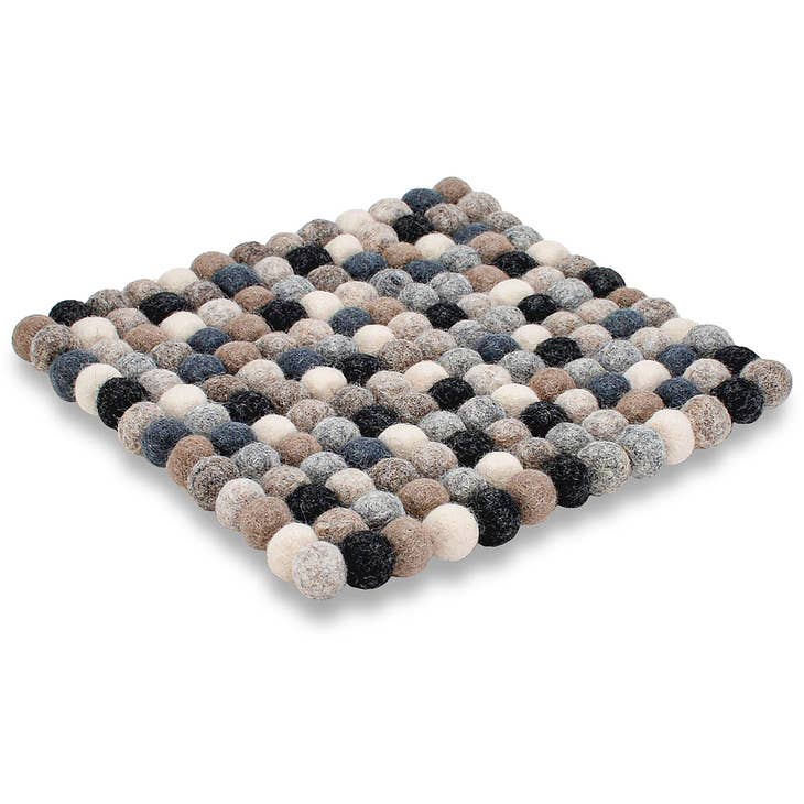 The Natural Wool Felted Pom-Pom Trivet is a square mat crafted from interconnected felt balls in gray, blue, black, and beige forming a grid pattern, serving as an elegant handcrafted table protector.