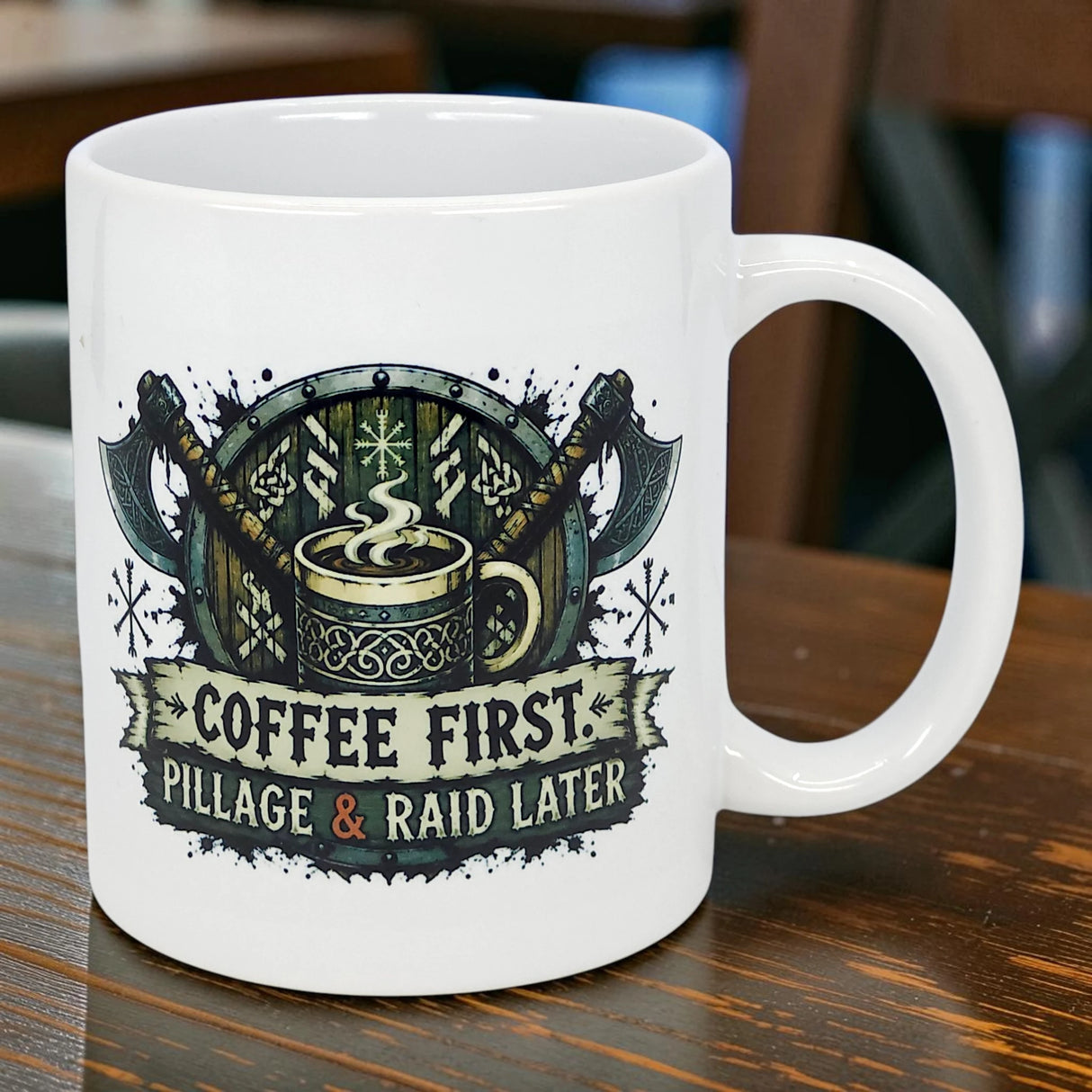 The Nordic Wholesale Mug: Coffee First Pillage and Raid Later Ceramic Mug (11 oz) features crossed axes, a steaming cup, and the phrase "COFFEE FIRST. PILLAGE & RAID LATER."—perfect for Norse coffee lovers with a sense of humor.