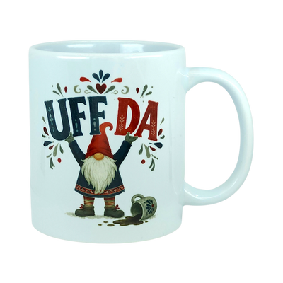 White ceramic mug with the text Uff Da and an illustration of a Scandinavian tomte gnome standing next to a spilled mug.