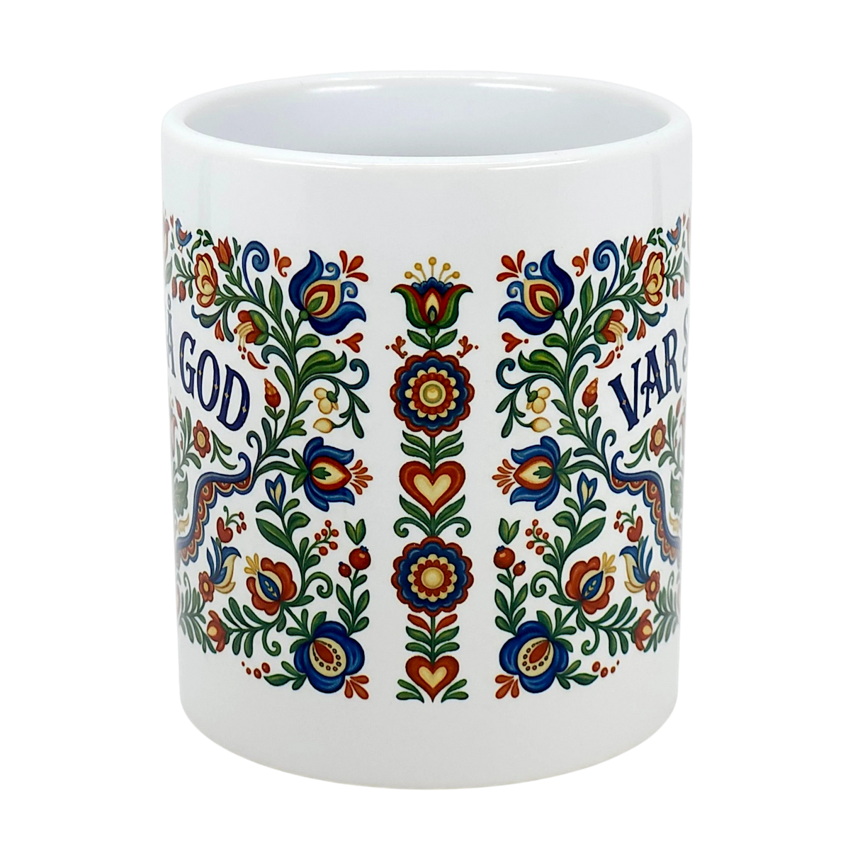 The Mug: Var Sa God Swedish Kurbits Folk Art Ceramic Mug (11 oz) by Nordic Wholesalers features colorful, symmetrical floral Nordic designs and the text "GOD" and "VAR," making it a perfect Scandinavian-style coffee cup.