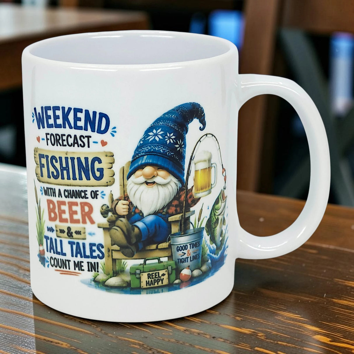 The Mug: Weekend Forecast Fishing Tomte Ceramic Mug (11 oz) from Nordic Wholesale features a Scandinavian gnome fishing with beer. Text: “Weekend forecast: Fishing with a chance of beer and tall tales. Count me in!” Great fishing gift!.