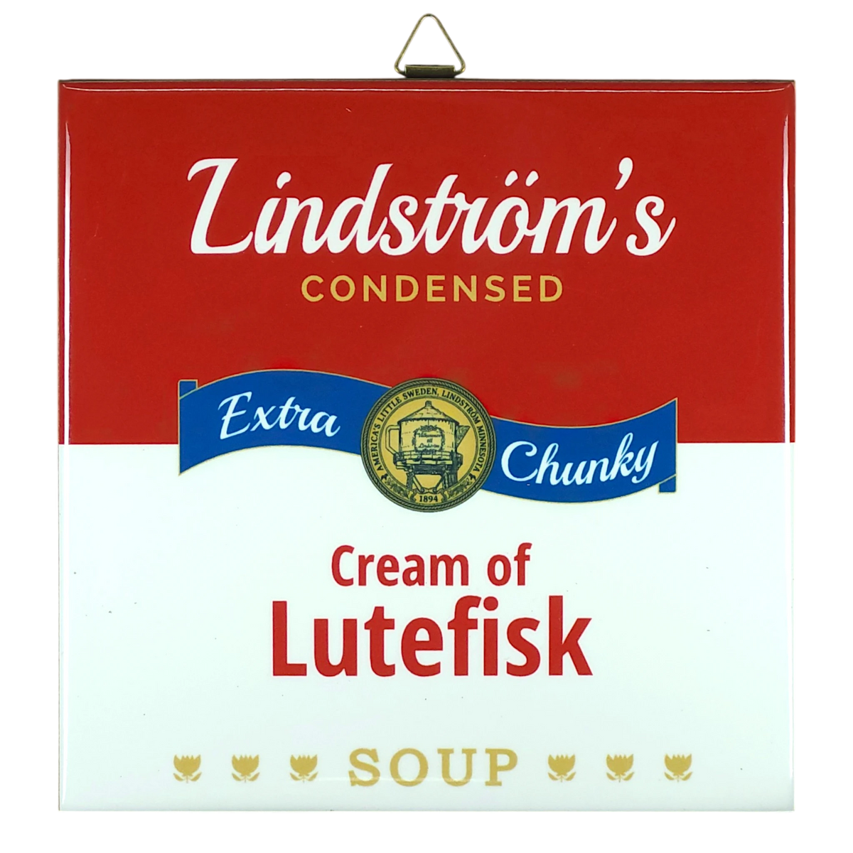 Ceramic wall tile styled like a red and white soup can label; text reads Lindströms Condensed Extra Chunky Cream of Lutefisk Soup, with a gold medal and three fish.