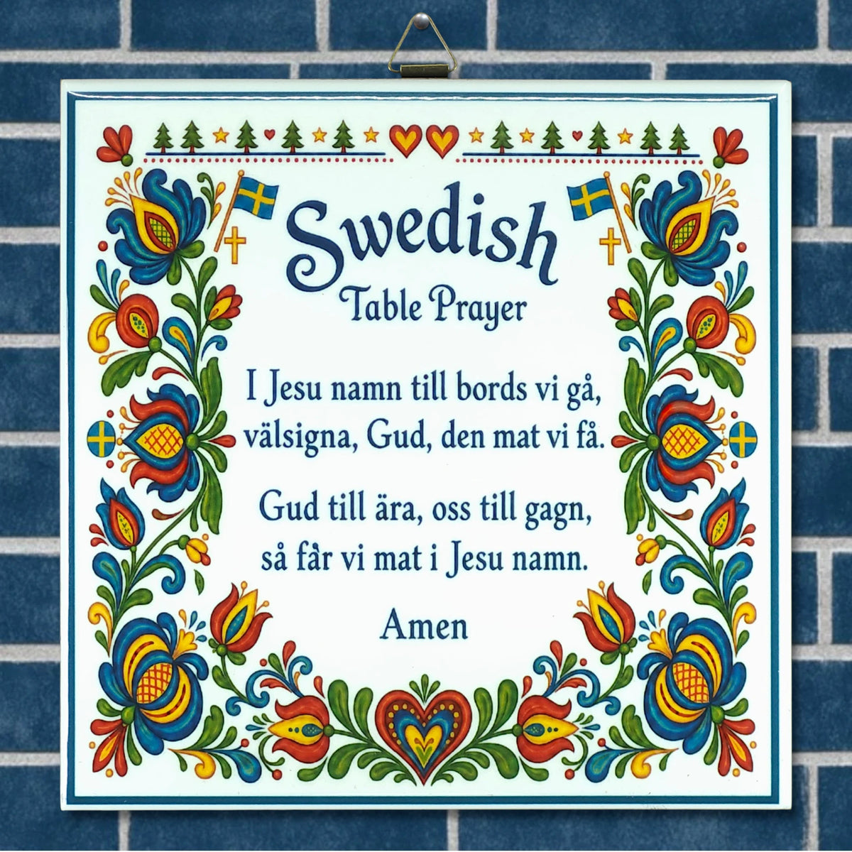 Decorative sign on blue tiles with the Swedish Table Prayer, colorful florals, hearts, flags, and kurbits motifs in a Scandinavian style.