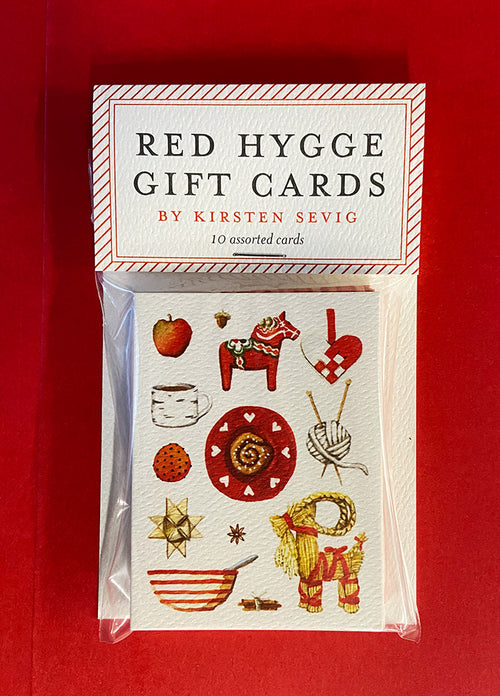 Pack of Red Hygge Gift Cards, showcasing 10 unique designs, such as a horse, cup, heart, snowflake, and other cozy elements in red and white on a red background. These blank cards display delightful Scandinavian patterns and are printed on recycled paper for an environmentally-friendly touch.