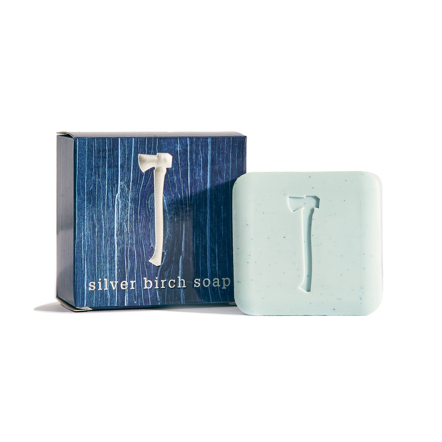 A light blue square vegan Silver Birch Soap 5.4 oz bar with an axe emblem is displayed next to its dark blue box labeled Silver Birch Soap.