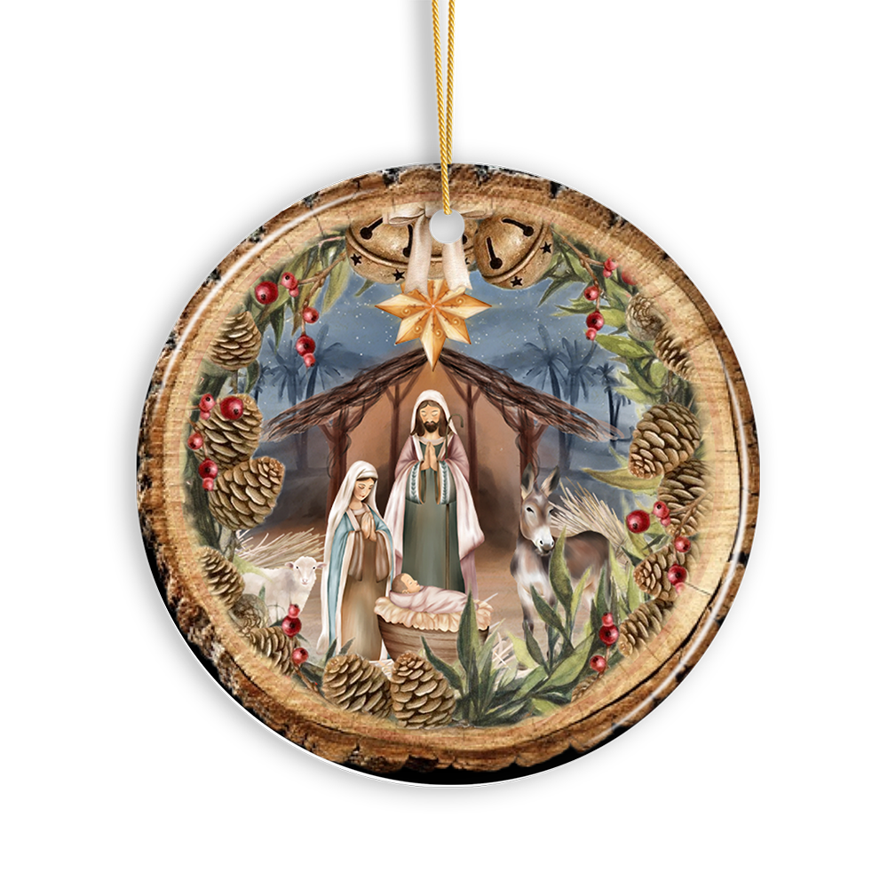 The Ornament: Rustic Nativity Birth of Christ Scene Ornament depicts a classic scene with Mary, Joseph, and baby Jesus in a manger amidst pine cones and holly. Made from sustainable ceramic, it offers timeless elegance and eco-friendly charm for your holiday decor.