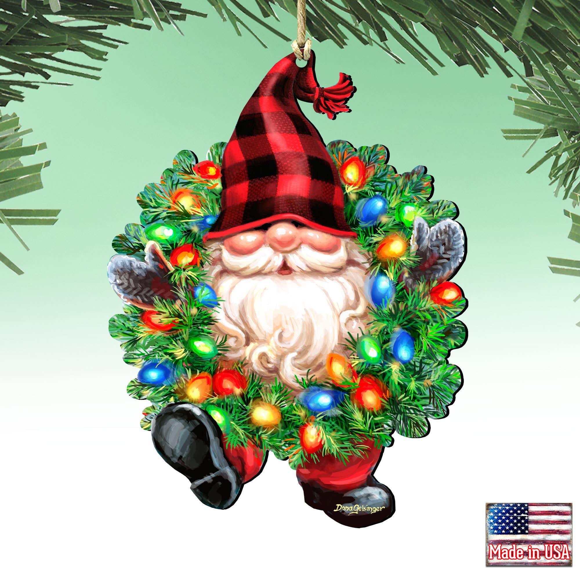 The Bright Light Gnome Ornament by D. Gelsinger (5.5x4.5 inches) is a handcrafted Christmas keepsake featuring a gnome in a red plaid hat, colorful lights, and festive wreath, with an American flag Made in USA label.