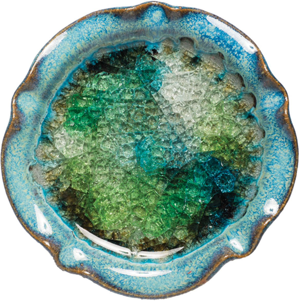 Handmade in the USA, this 5.75" diameter pottery candle holder features a blue rim and a glossy, textured interior with green, blue, and clear recycled glass fused together. Perfect for pillar & ball candles.