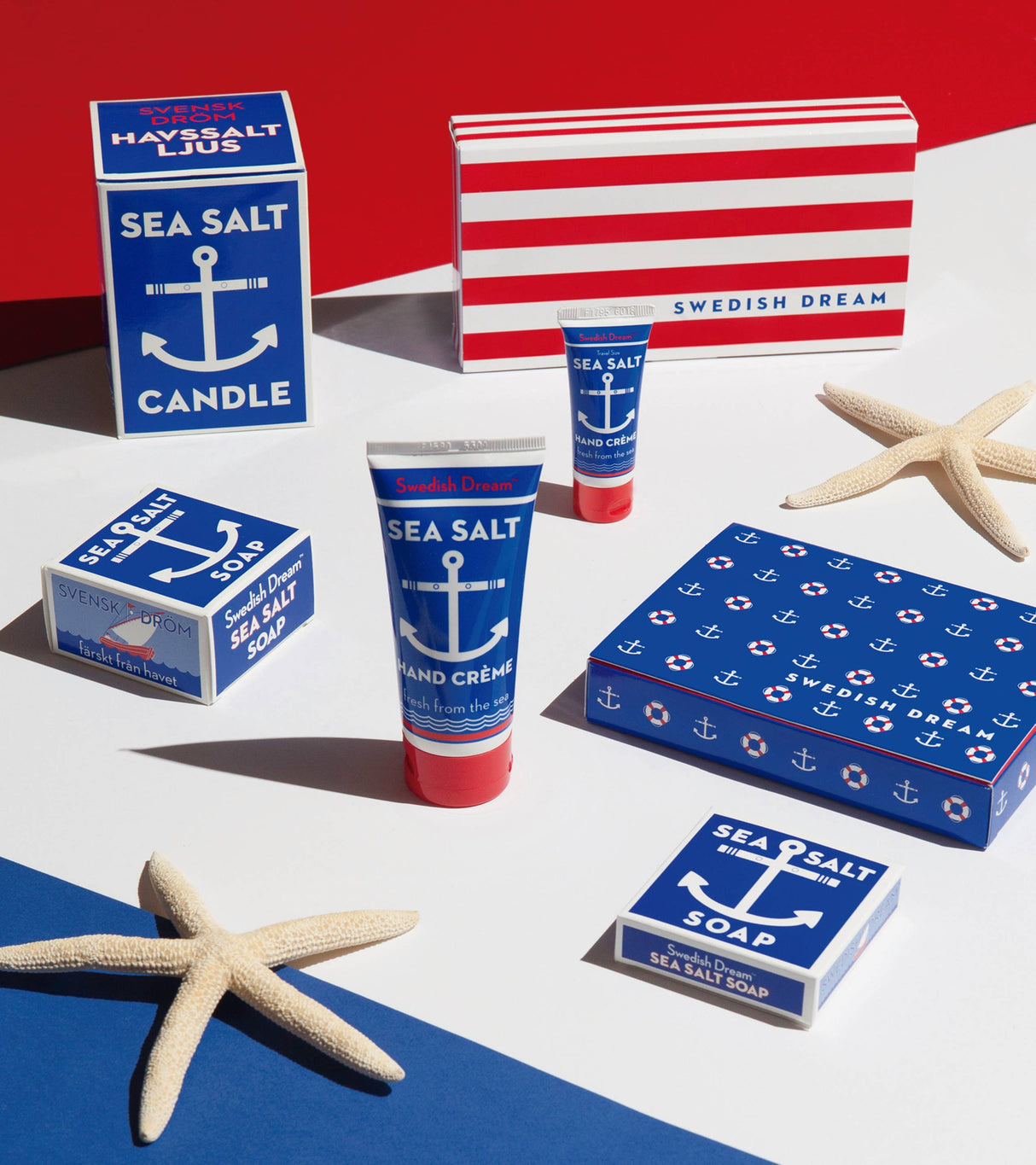 A selection of Swedish Dream Sea Salt items, featuring vegan and cruelty-free products like the Sea Salt Soap, along with hand cream and a candle, beautifully arranged with starfish on a red, white, and blue backdrop.