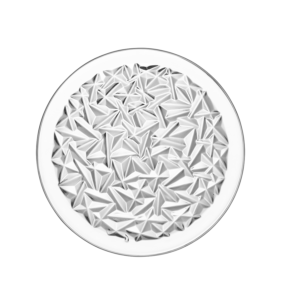 The Orrefors: Carat Dinner Plate, designed by Lena Bergstrom, is a round crystal glass plate with a faceted geometric center pattern inspired by angular shapes.