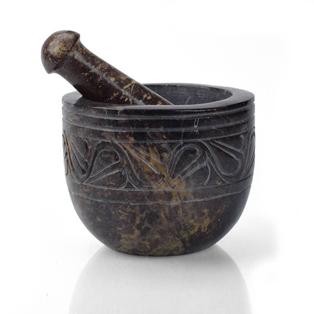 The Mortar & Pestle: Etched Gorara Rose Stone Mortar & Pestle, with intricate carved patterns and a matching pestle, rests on a plain white background—ideal for grinding fresh herbs.