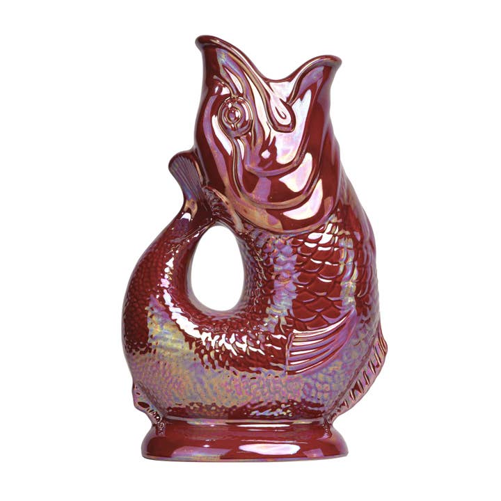 The Gluggle Jug Lustre by Faire - The Original Gluggle Jug Factory is a glossy, iridescent red fish-shaped pitcher with an open mouth, curved body handle, and intricate scales and fins, made in Europe.