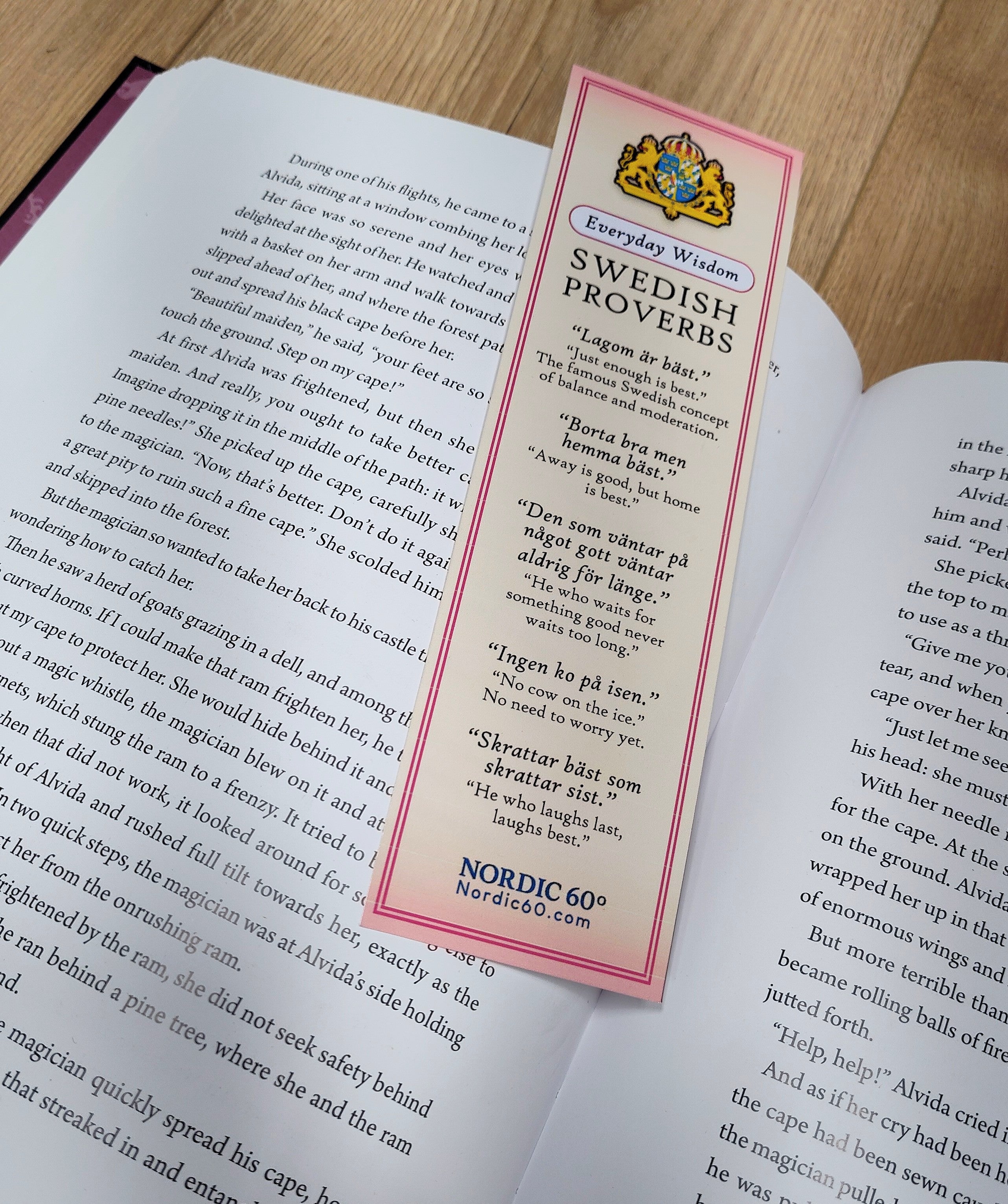An open book displays the Bookmark: Swedish Proverbs “Everyday Wisdom” (2.5" × 8.5"), featuring proverbs and their English translations, resting on the right page.