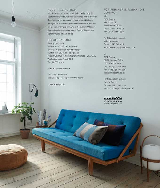 A modern living room with a blue sofa, assorted pillows, wood floors, and bright natural light perfectly embodies Scandinavian style as featured in Scandinavian Home Interiors Inspired by Light by Niki Brantmark.