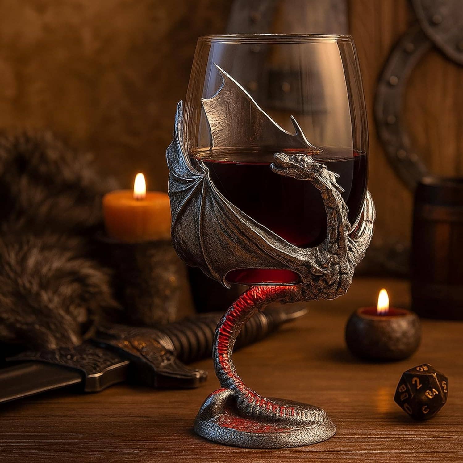 The Goblet: Medieval Dragon Viking Goblet Mug, 12oz filled with red wine sits among candles, fur, a dagger, and a twenty-sided die—an enchanting Fantasy Drinkware piece for any fan’s tabletop setting.