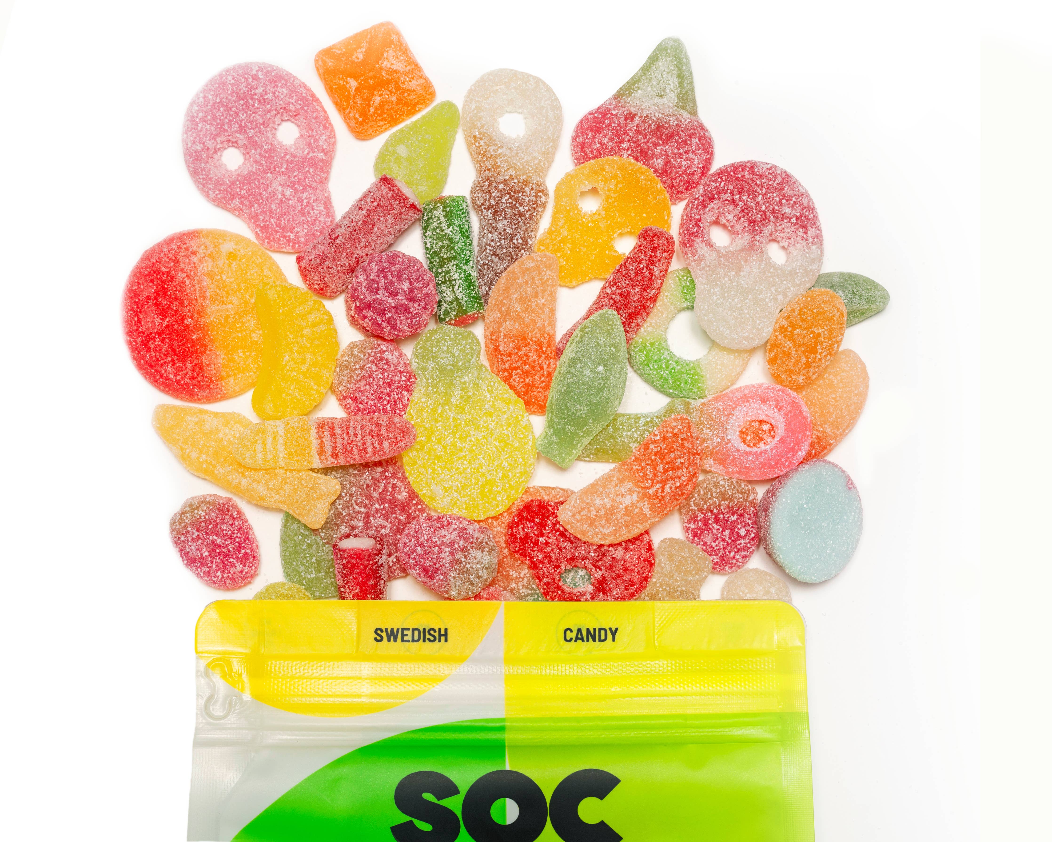 A vibrant mix of colorful Swedish Sour Gummies spills from an 8 oz yellow and green bag labeled "Candy: Sour Gummy Mix Swedish Candy," made with Non-GMO ingredients.