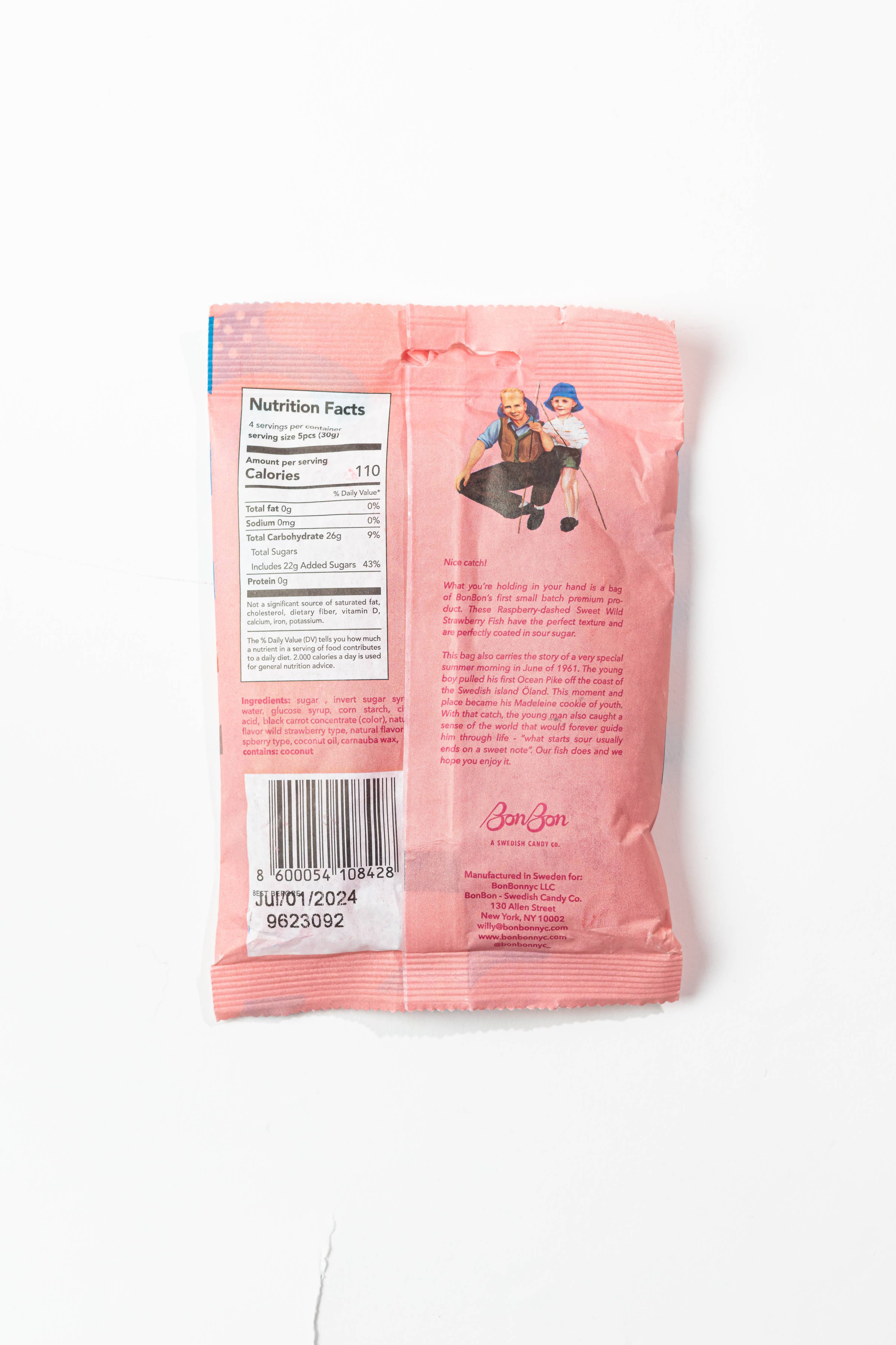 The packaging for Candy: BonBon - Sweet Wild Strawberry Fish (150g) Swedish Candy is pink, highlighted with a nutrition facts label and barcode on the back. Near the top center, it features small illustrations of two cartoon characters. This vegan and gluten-free treat captures the essence of classic Swedish candy with its delightful wild strawberry flavor.