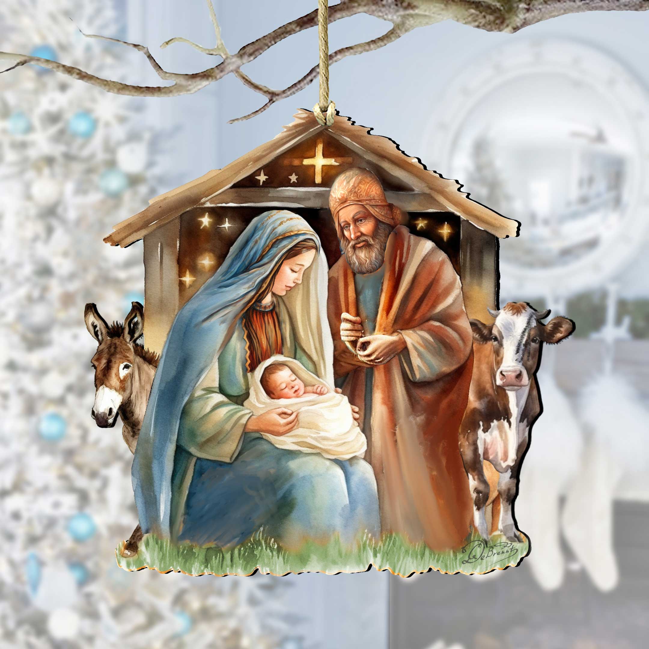The Ornament: Born Under Bright Star Nativity by G. DeBrekht is a handcrafted wooden piece featuring Mary, Joseph, baby Jesus, a donkey, and cow in a stable. Approx size: 5 x 4.75 inches; perfect for hanging on your Christmas tree.