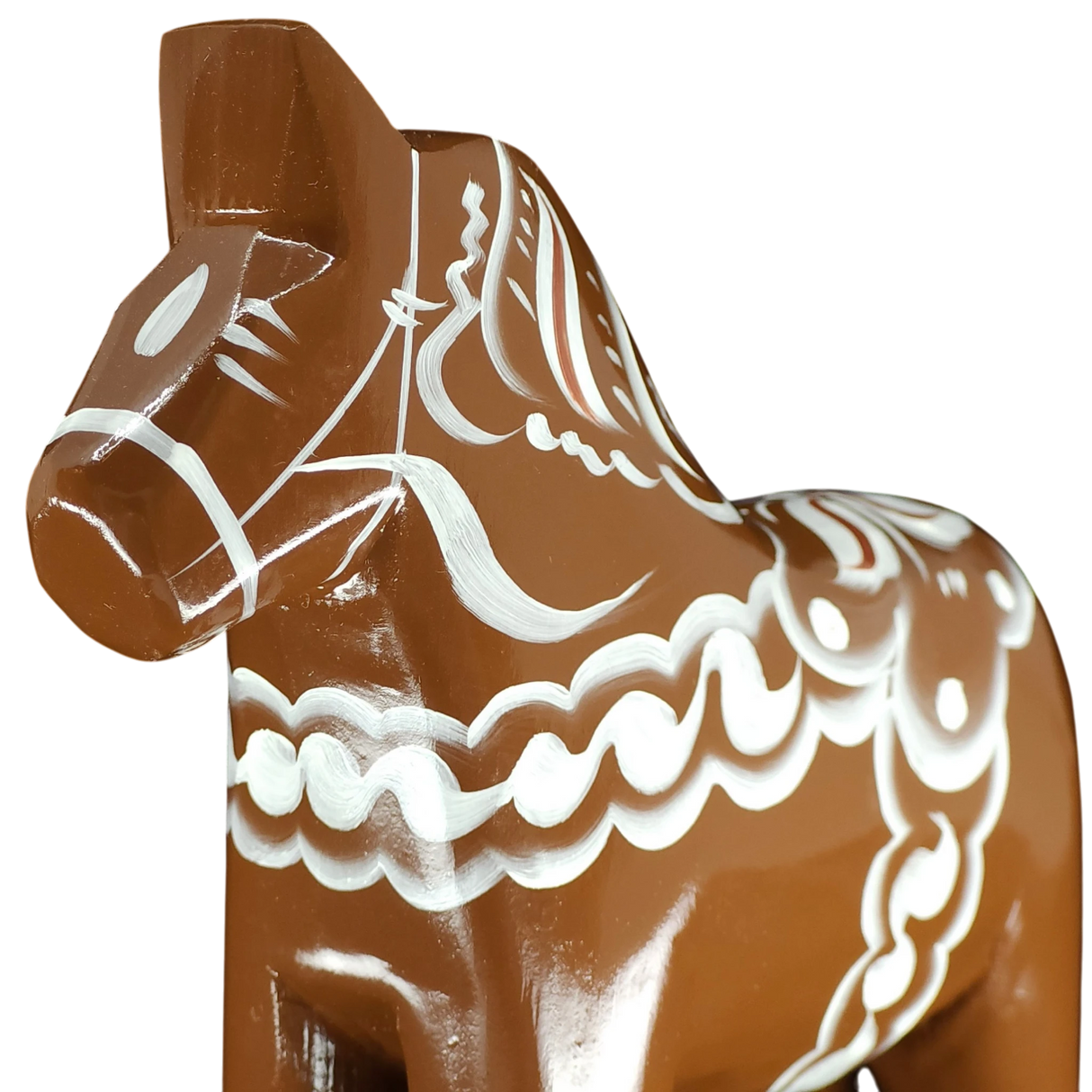 A close-up of the Grannas Olsson Dala Horse: Brown Swedish Dala Horse "Gingerbread" (13 cm), handcrafted in Sweden and adorned with intricate white patterns, is set against a plain white background.