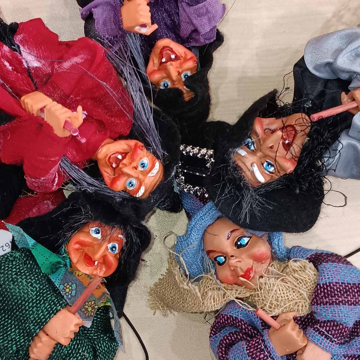 The Walburga Purple Kitchen Witch Doll features exaggerated facial features and vibrant clothing, making it a whimsical and colorful addition to your folklore décor.