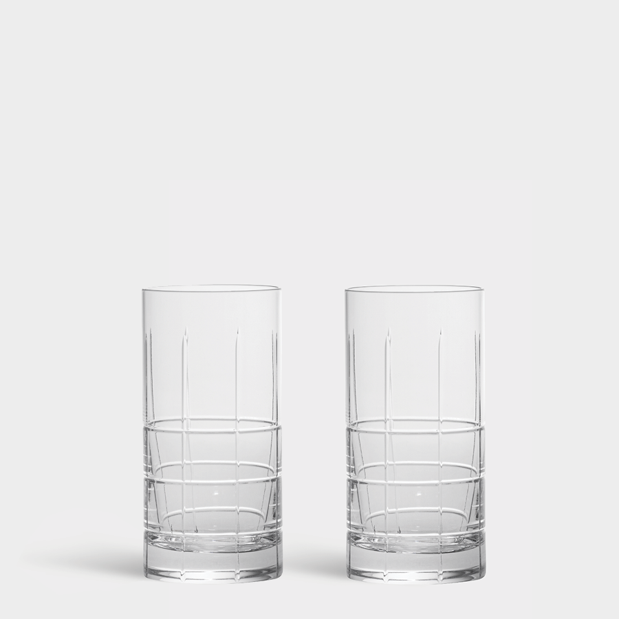 Two clear Orrefors Street Highball Glasses (15oz, 2-Pack) with vertical etched lines elegantly stand against a white background, showcasing Jan Johanssons exceptional design craftsmanship.