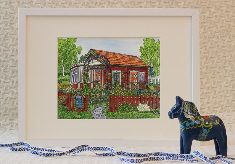“Swedish Dream” by Greta Lann, an 8x10 print, features a red cottage and garden in Swedish house print style, shown with a blue decorative horse and blue-and-white ribbon on a patterned background.