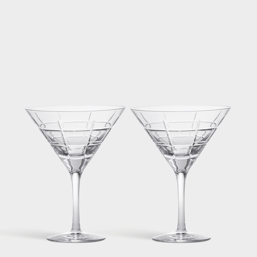 The Orrefors Street Martini Glass 2-Pack, designed by Jan Johansson, features two clear glasses with striking geometric patterns resting elegantly on a plain white background, capturing a perfect blend of artistry and functionality.