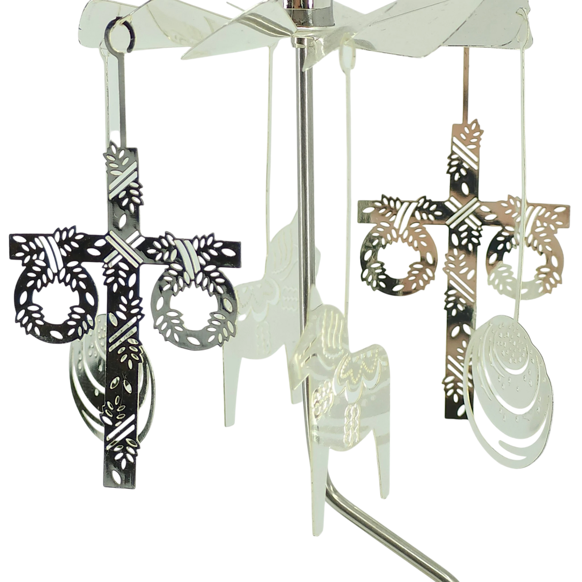 Scandinavian-style rotary candle holder with four hanging metal ornaments, including cross designs with wreath accents, shown against a white background.