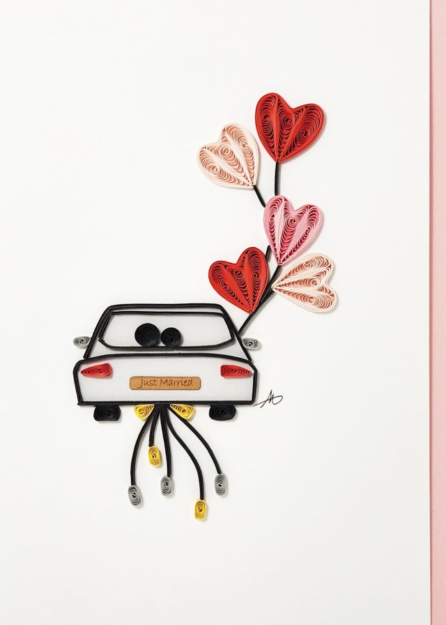 Celebrate a wedding with the Card: Just Married Couple in Car with Hearts and a Bow Quilling Card 5x7—handcrafted, featuring a car adorned with hearts and bows. A unique way to send your best wishes to the happy couple!.