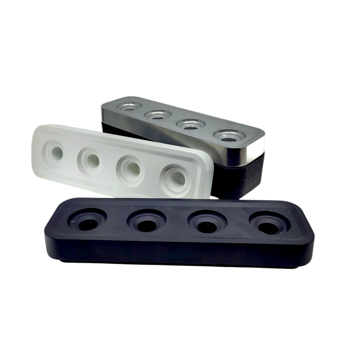 Three black, white, and gray rectangular silicone molds have four circular cavities each and are staggered like Stumpastaken Swedish Candle Holders, making them eco-friendly for any setting.