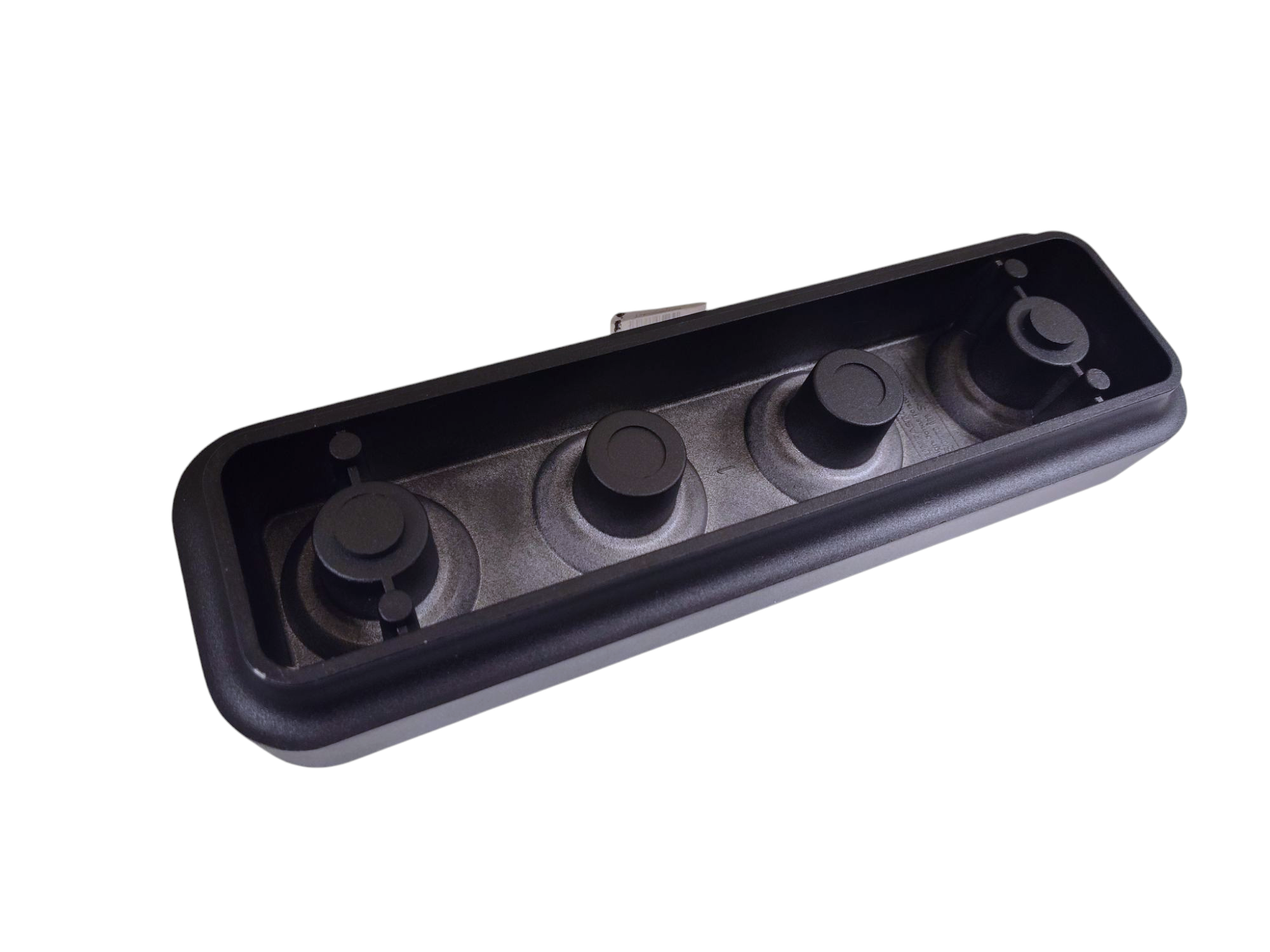 Close-up of a black rectangular object featuring four circular buttons in a linear arrangement, echoing the minimalist design characteristic of a Stumpastaken Swedish Candle Holder.