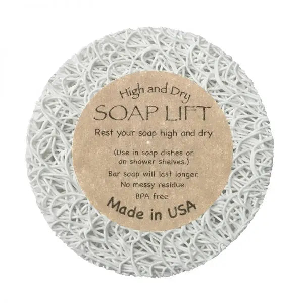 The Soap Lift: Round A Bout Soap Lift Soap Saver is a white, round pad with a textured web-like surface and brown label. It keeps bar soap dry and mess-free, is eco-friendly, BPA free, Made in USA.
