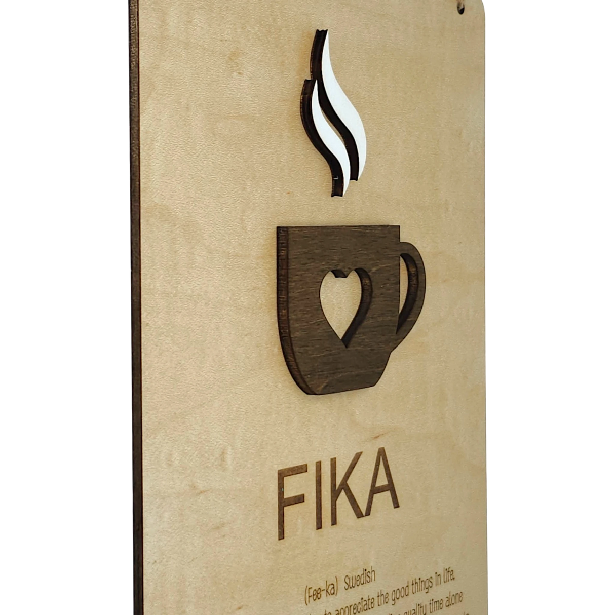 Wooden plaque featuring a heart-shaped coffee cup cutout with rising steam and the word “FIKA” below, displayed on a light wood background.