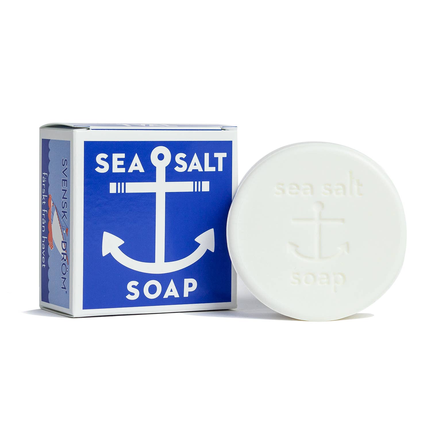 A round bar of Soap: Sea Salt Soap - Swedish Dream, embossed with an anchor, is paired with its matching blue and white packaging. This cruelty-free product blends natural elegance with nautical charm, making it an ideal addition to any eco-conscious skincare routine.