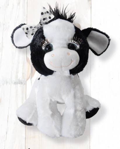 A 10-inch "Lash'z Cow" plush toy featuring a black and white design, large eyes, a spotted bow on its ear, and a cheerful smile, making it an ideal cuddly cow gift for girls, set against a light background.