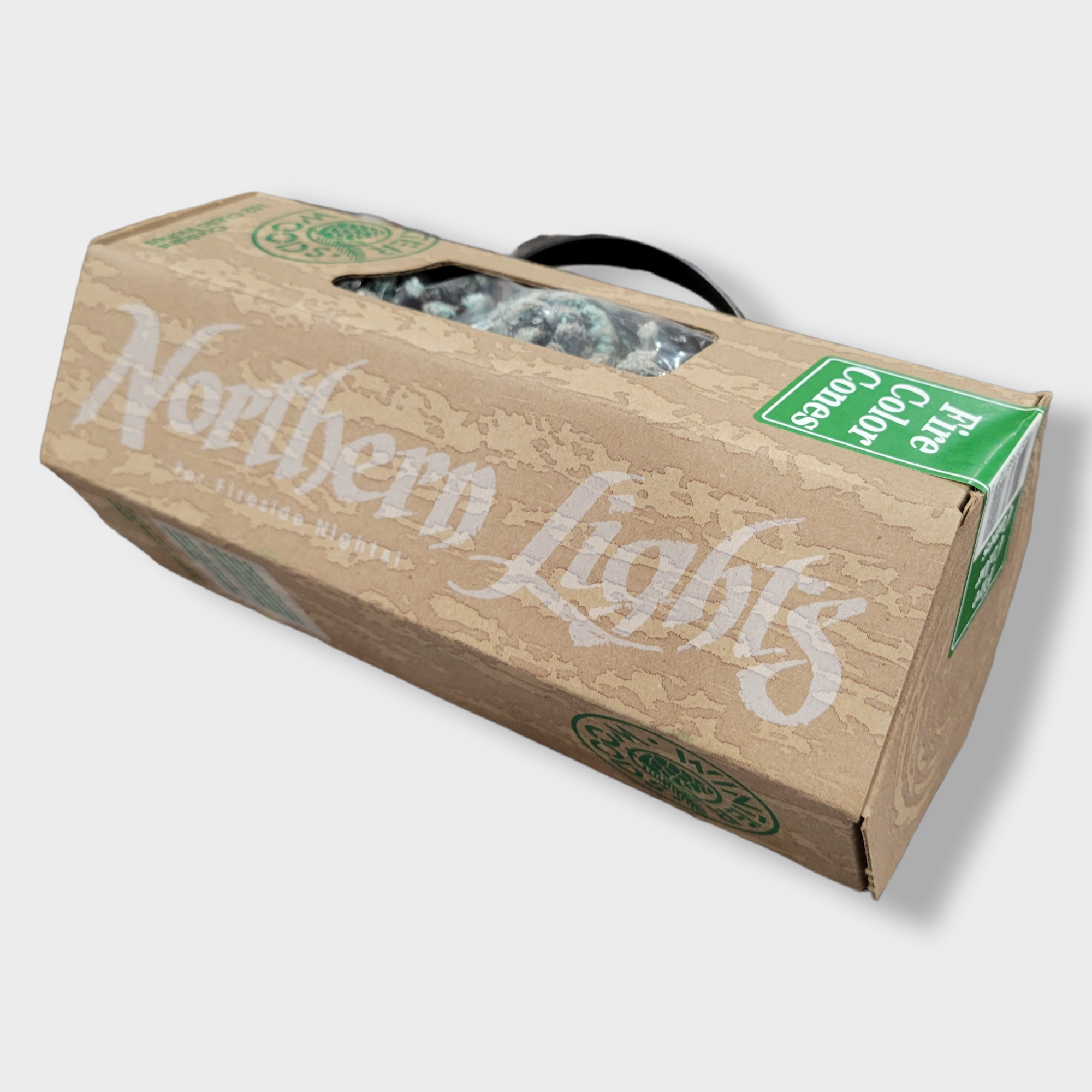 A cardboard box labeled Fire Color Cones: Northern Lights for Fireside Nights with a transparent window reveals colorful fire color cones and a green sticker in the corner that says Five Color Donuts.