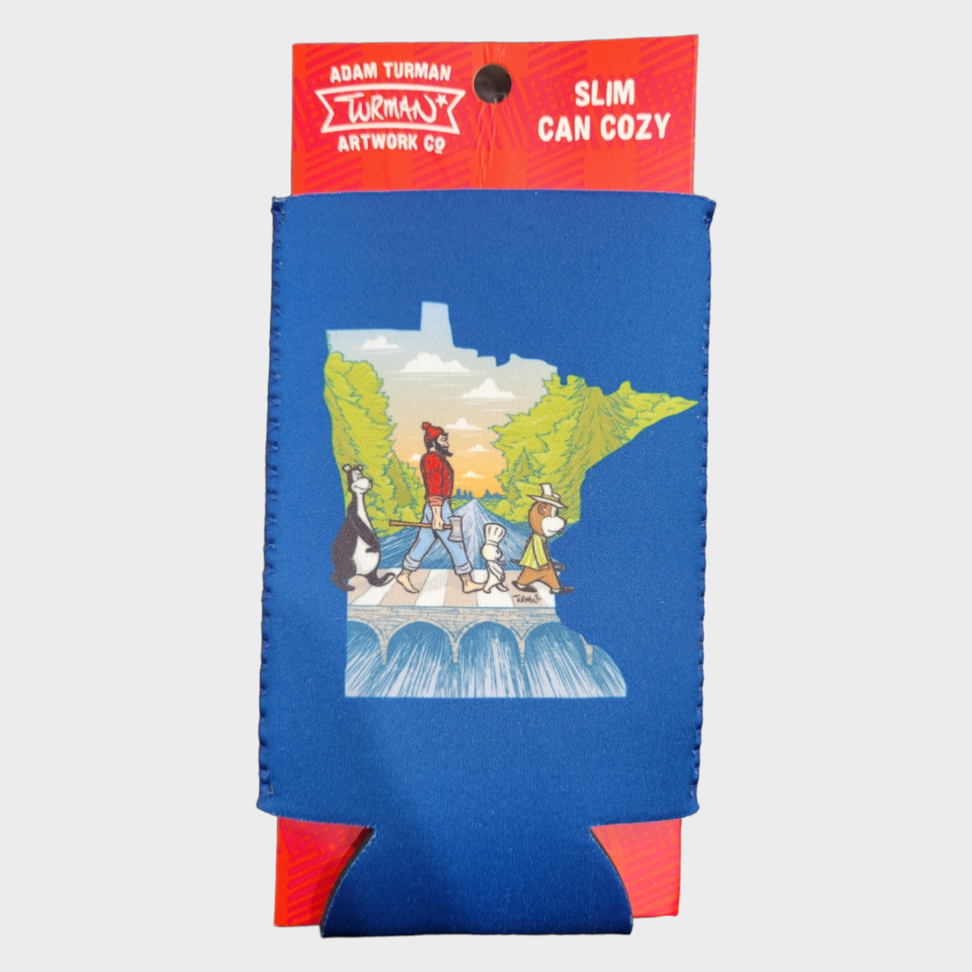 The Can Cozy: Abbey Road Minnesota State Slim Can Cozy by Adam Turman features cartoon animals on a bridge, with the Minnesota State outline and city skyline in the background. Packaging reads Adam Turman Artwork Co.