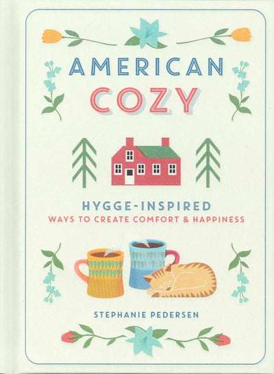 Cover of Book: American Cozy Hygge - Inspired Ways to Create Comfort & Happiness features a red house, mugs, a sleeping cat, and decorative floral and tree patterns embodying the essence of Hygge-inspired comfort and happiness.